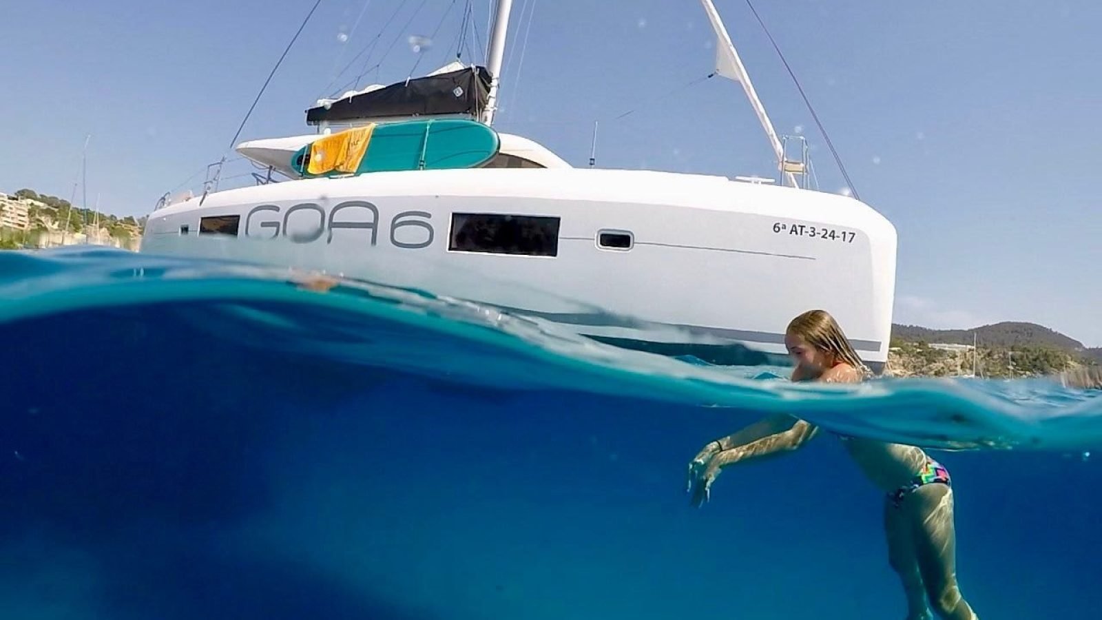 Catamarán Lagoon 42 de Marina La Cruz fondeado en agua turquesa con una nadadora junto al casco, renta de yate cerca de Litibú y Punta de Mita
